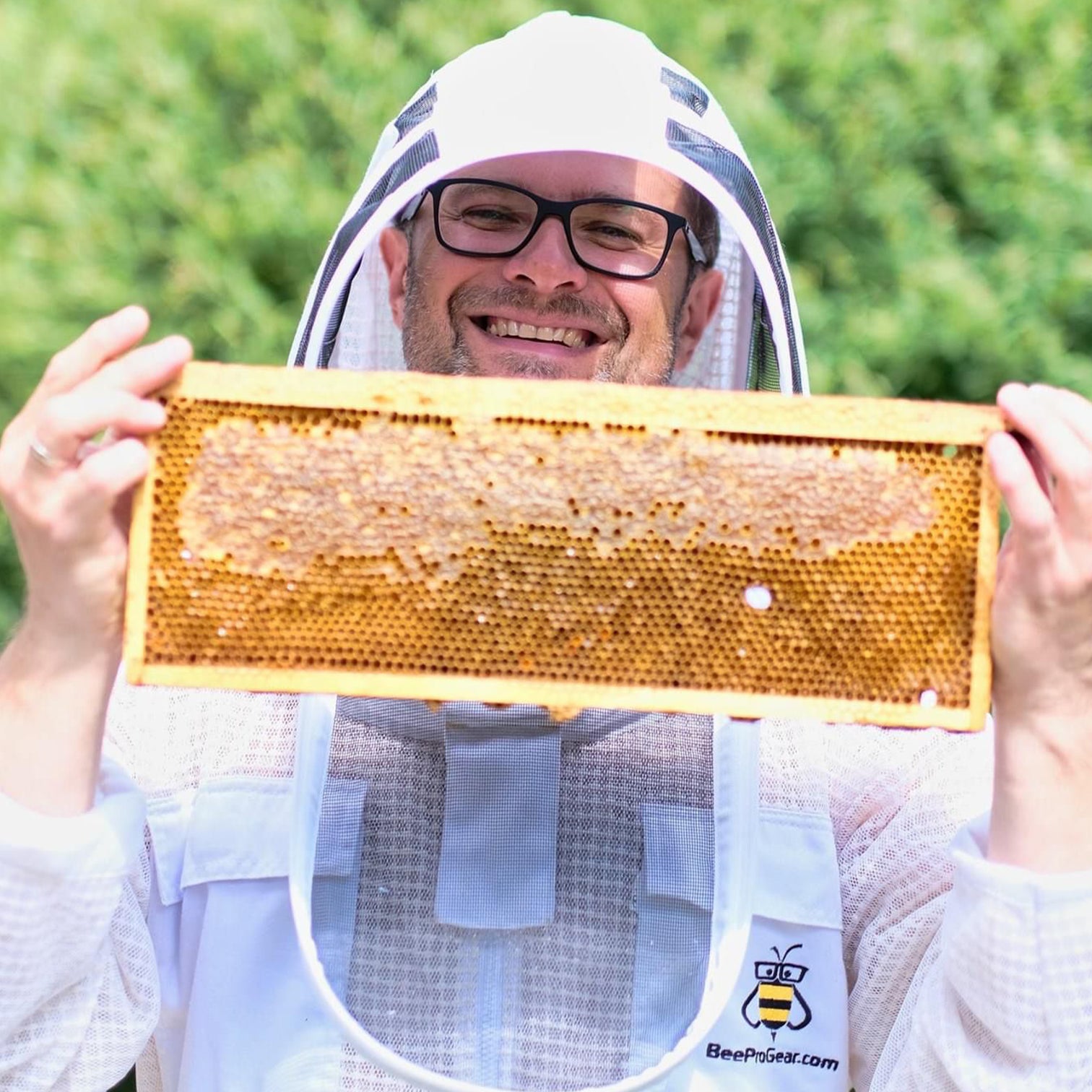 Beekeeper smiling with honeycomb